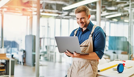 Handwerker nutzt Faktura-Software auf Laptop