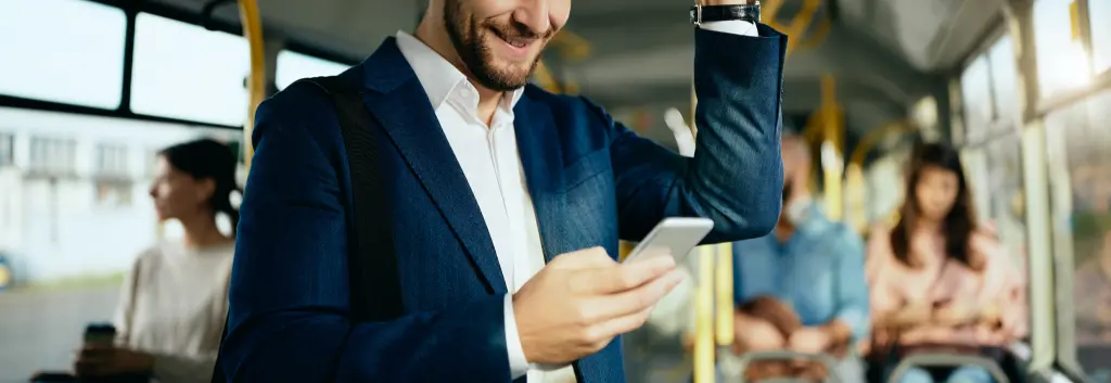 Mann in Business-Kleidung informiert sich während der Busfahrt über die pendlerpauschale 2026.
