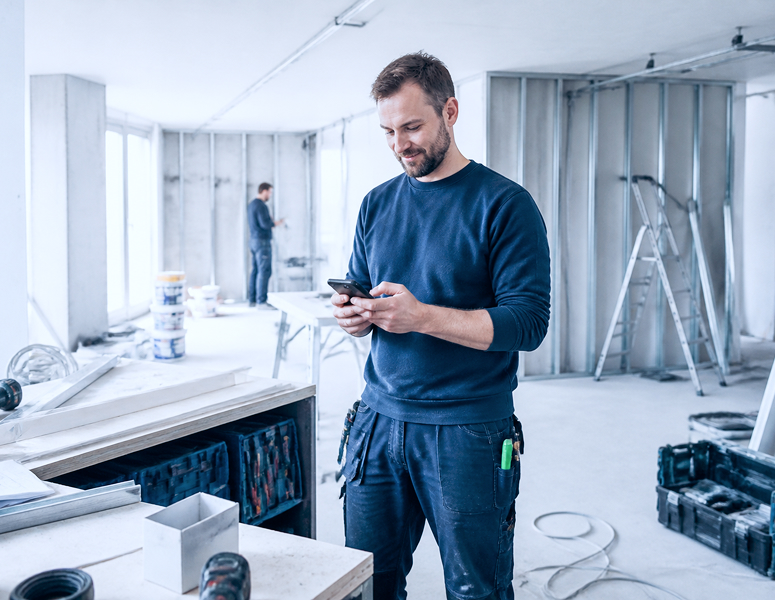 Ein Handwerker mit einem Smartphone